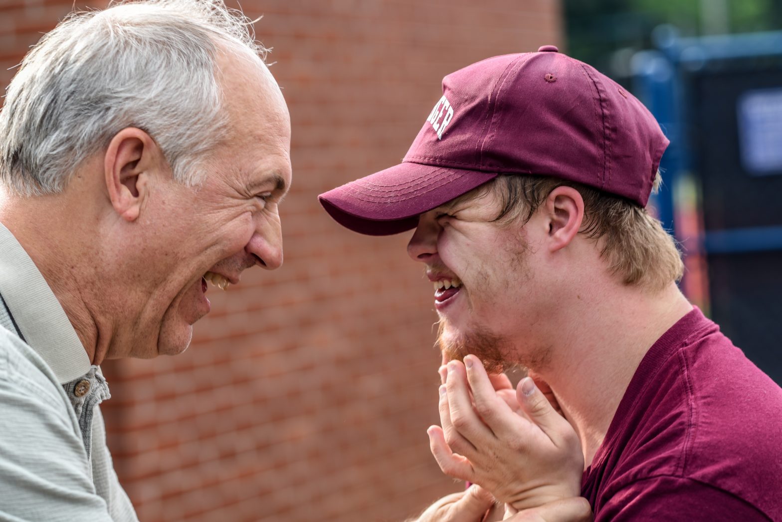 Two men facing each other and smiling with delight.